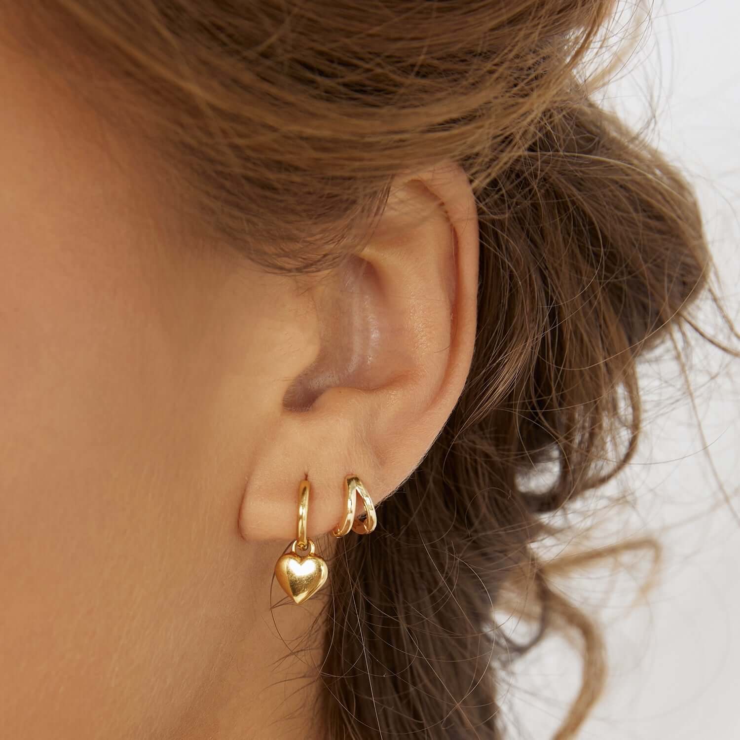 Gold hoop earrings with heart charm
