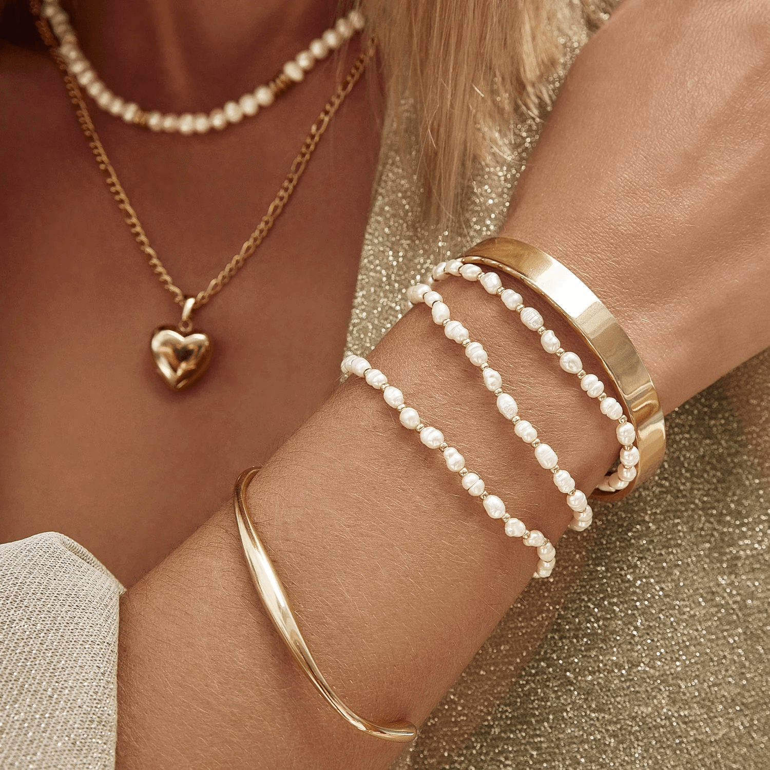 Model wearing gold cuff bracelets