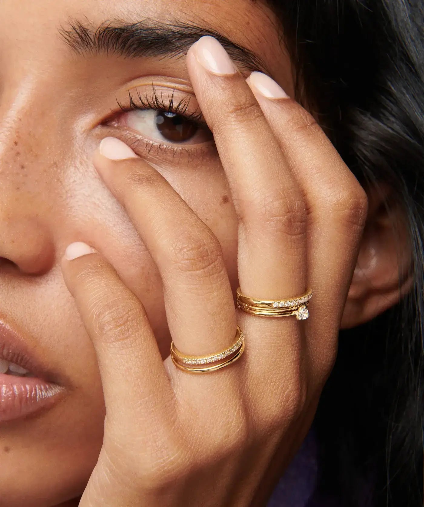 Model wearing gold rings stacks
