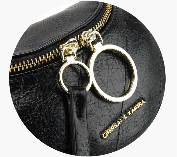 Luna black leather bag close-up of gold zipper pull and interlocking O-ring hardware detail - Valentina