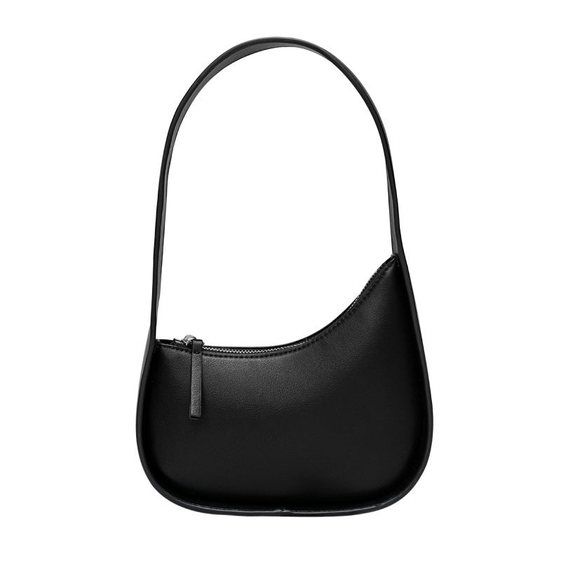 A black leather shoulder bag with a half moon design, featuring a wide shoulder strap and a soft handle.