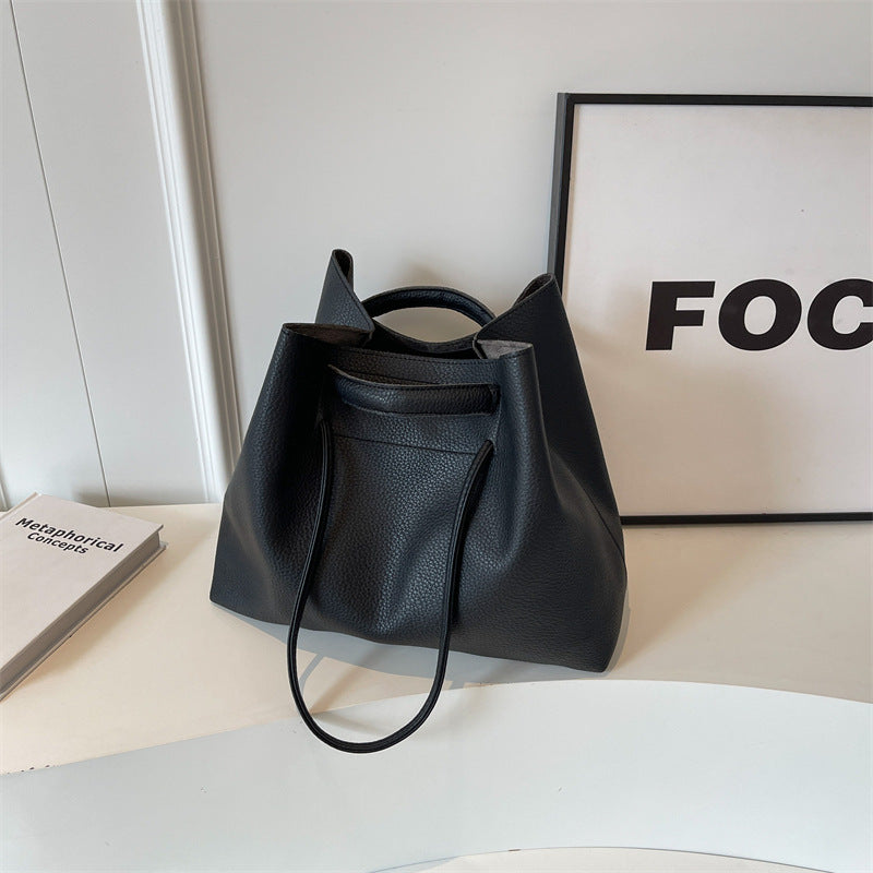 A brown underarm tote bag displayed on a flat surface, with its handle and shape visible.