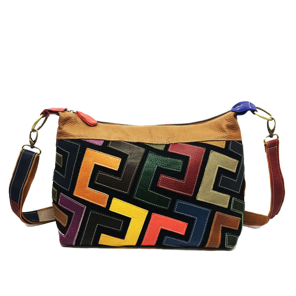 A colorful geometric patterned shoulder bag with a tan leather finish and a red wristlet strap Front View