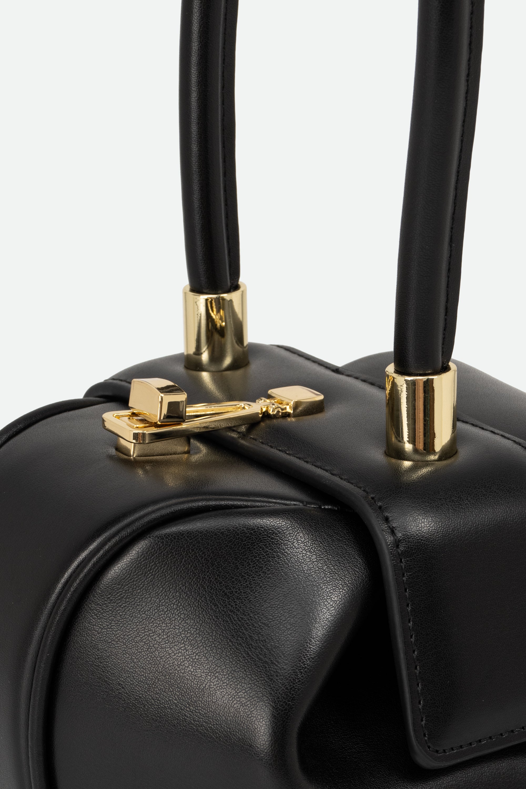 Black handbag with gold accents on a light gray background