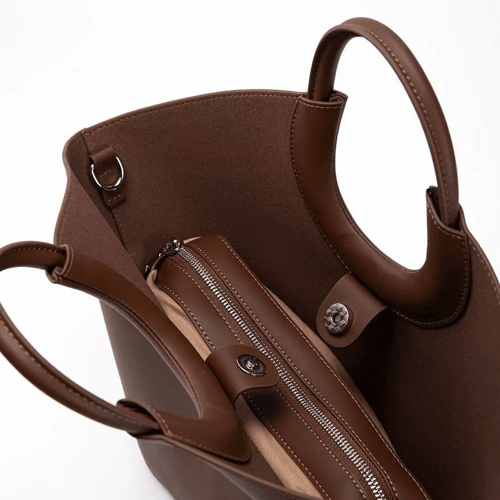 Brown leather handbag with a zipper on a white background