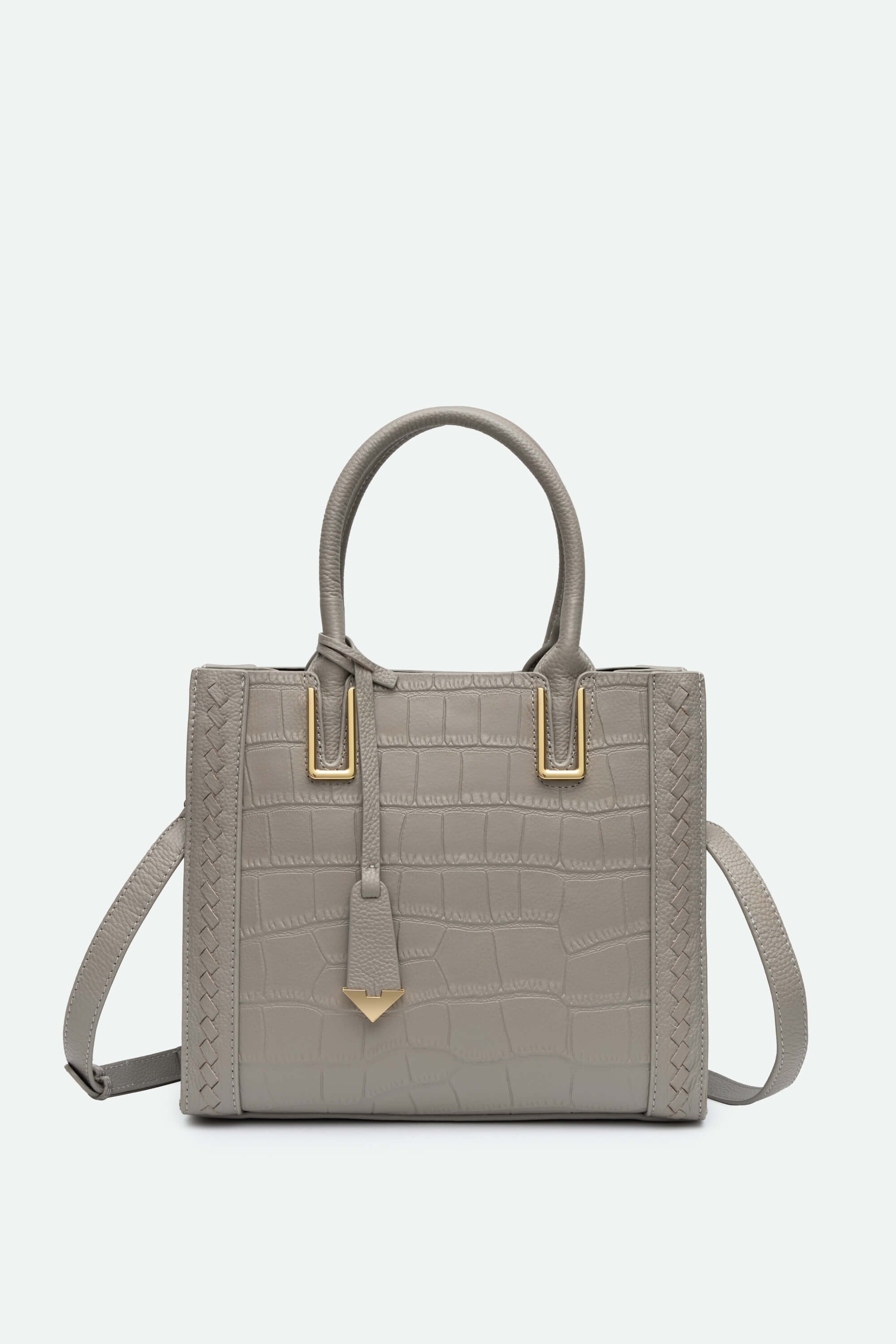 Gray handbag with gold accents on a light gray background