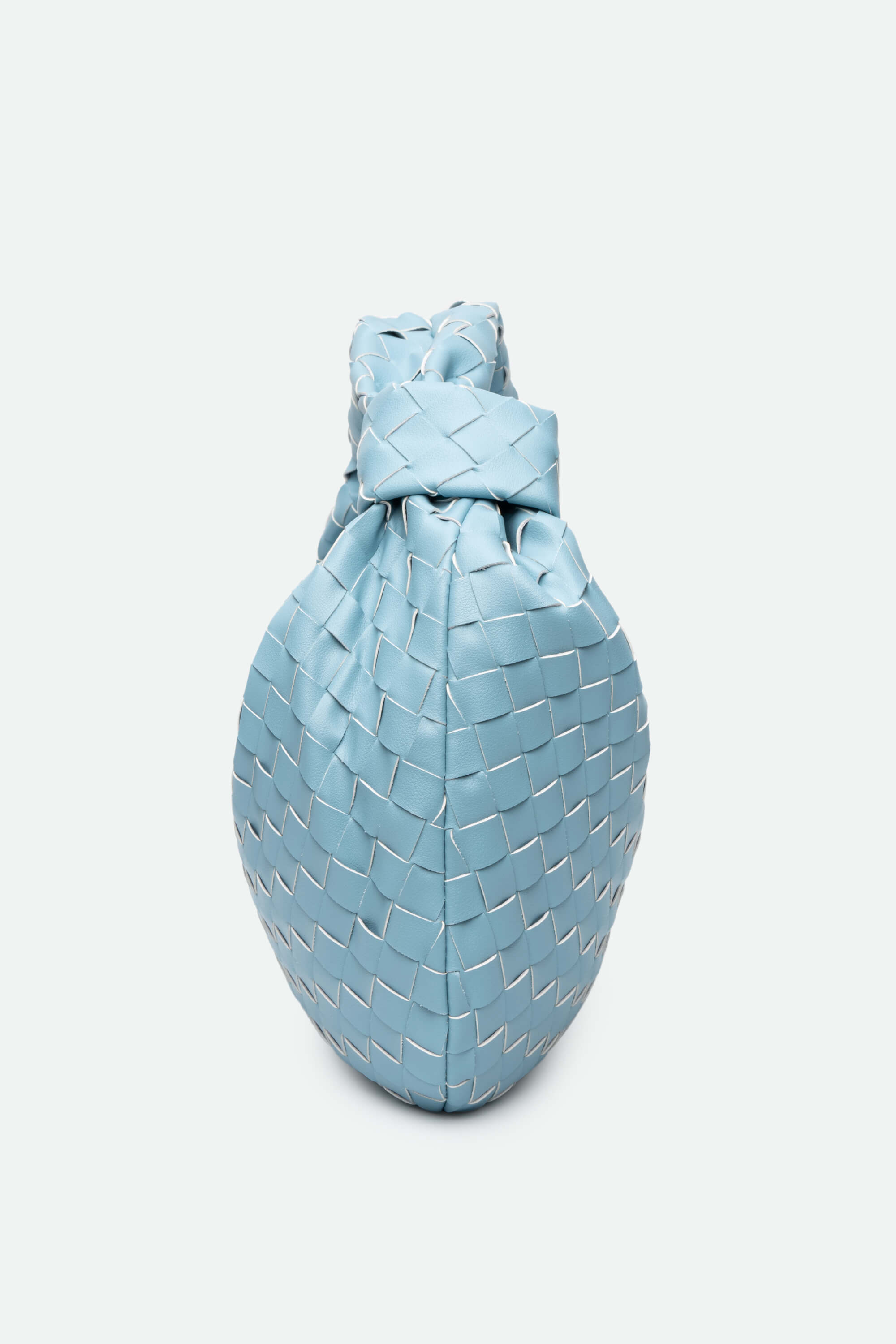 Light blue woven handbag on a white background