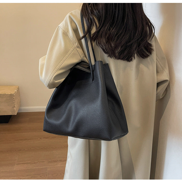 Person holding a black handbag in an indoor setting