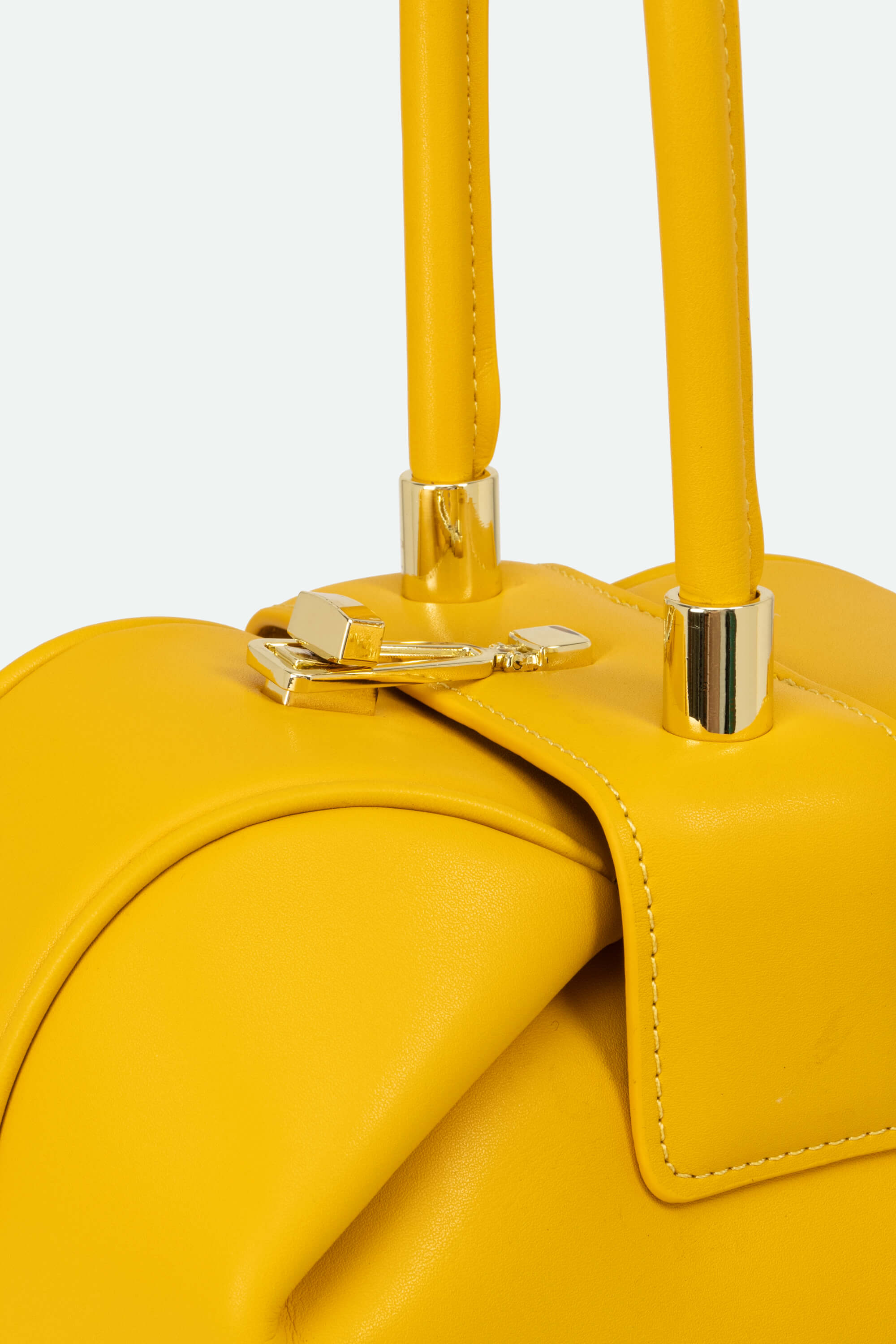 Yellow handbag with gold clasp on a light gray background