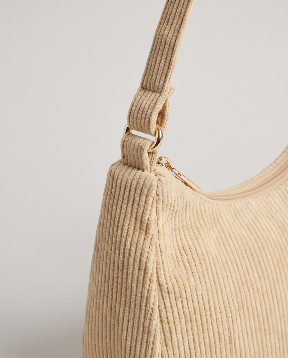 Aura corduroy shoulder bag in Beige – close-up of the corduroy, zip and strap fitting