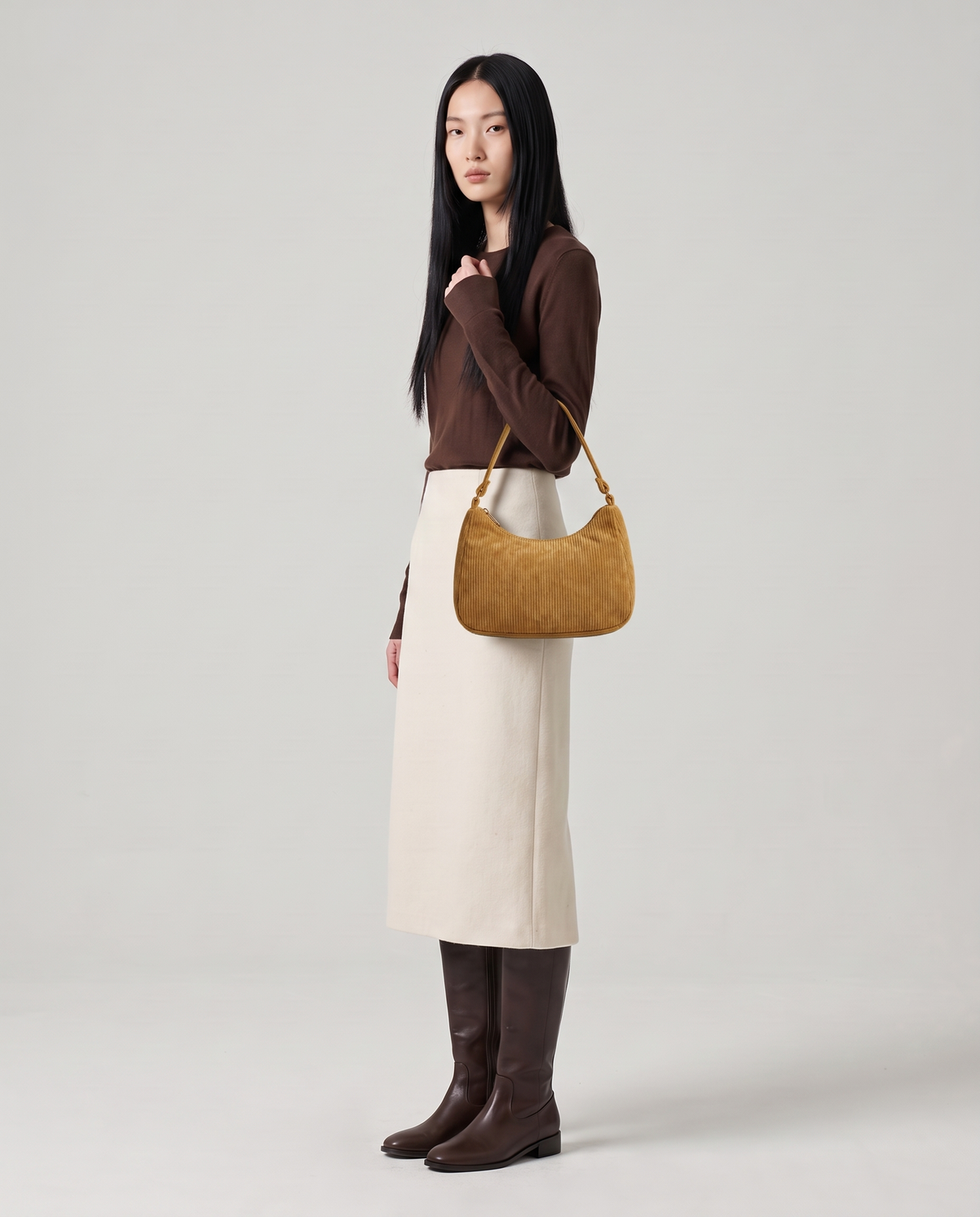 Aura corduroy shoulder bag in Tan – model wearing it on her shoulder, full length