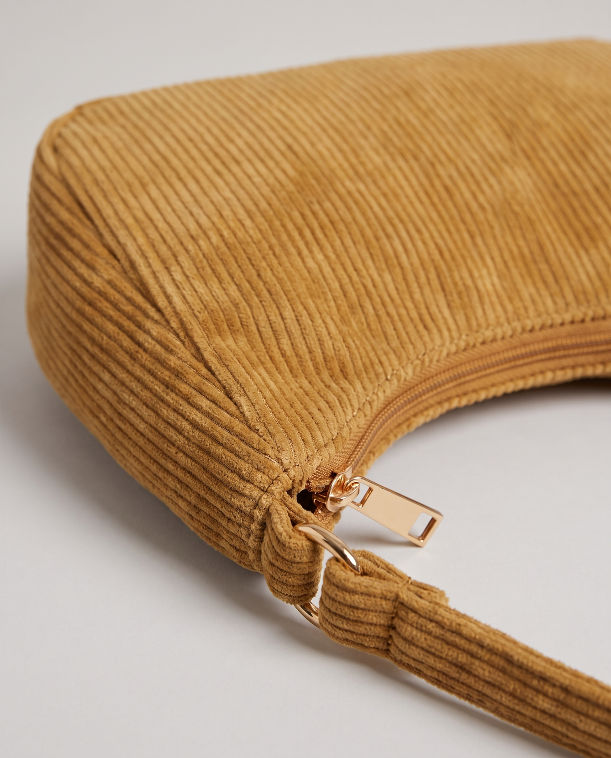 Aura corduroy shoulder bag in Tan – close-up of the corduroy, zip and strap fitting