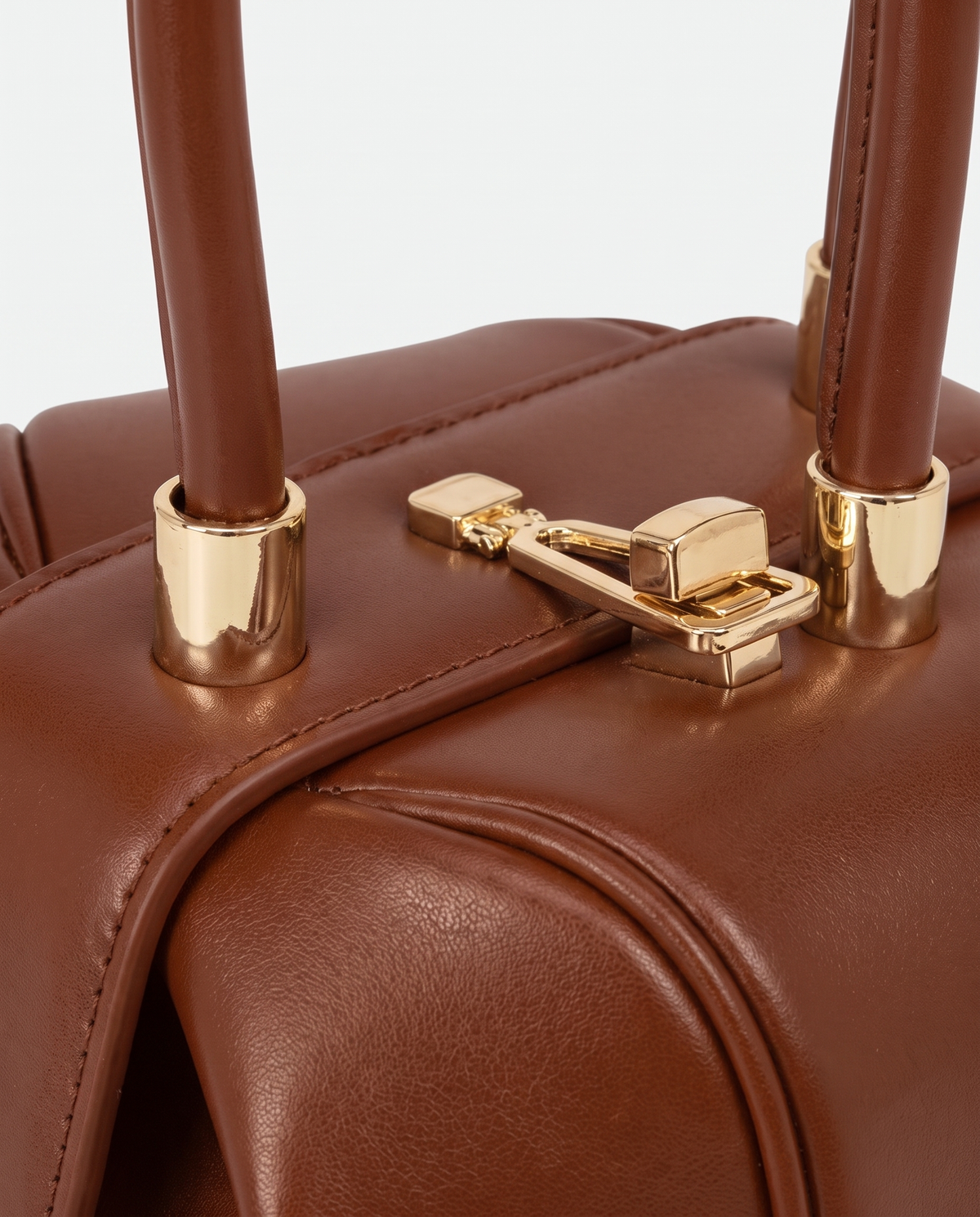 Dumpling Maxi leather top-handle bag in Brown – close-up of the gold twist-lock and handle fittings