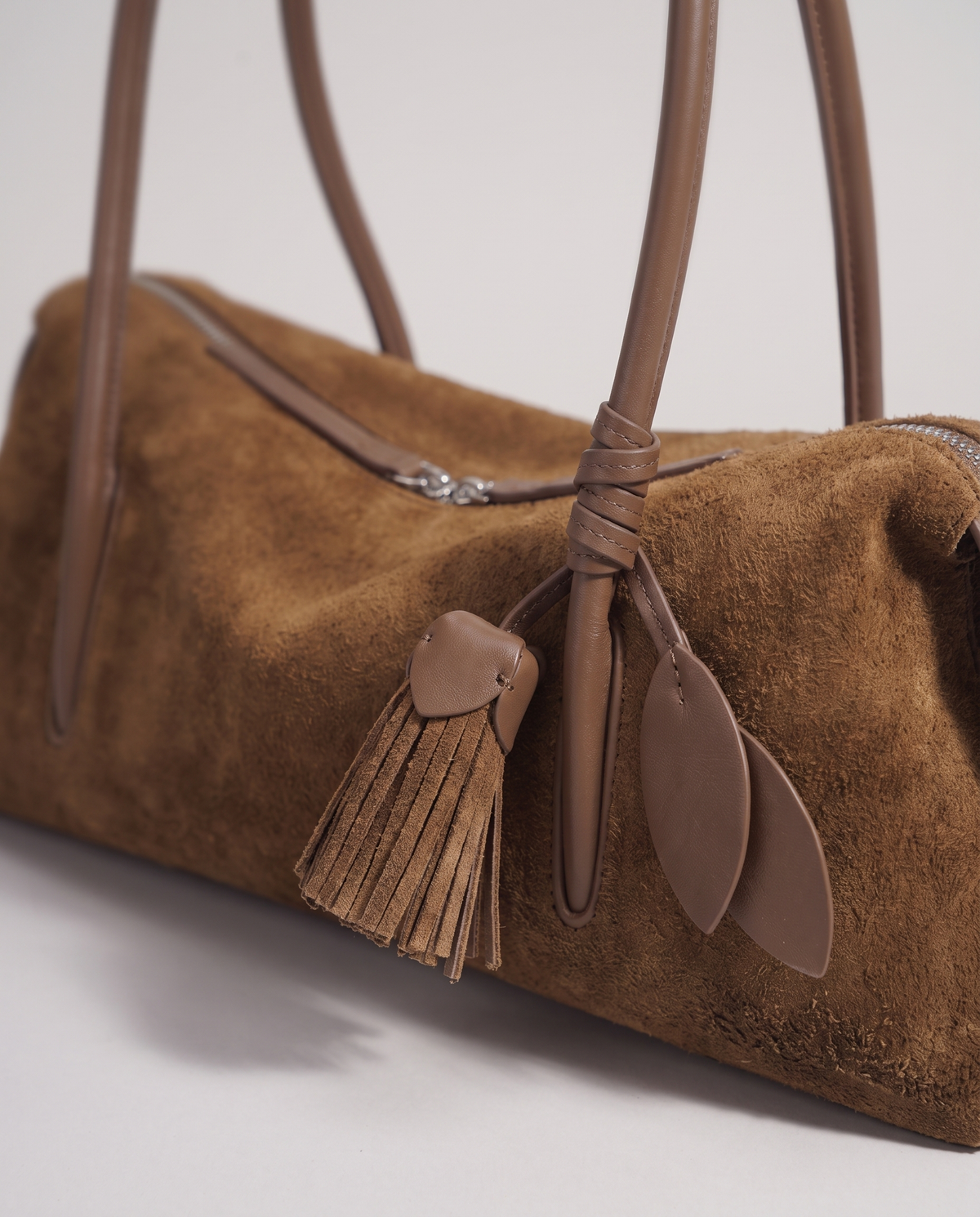 Isola suede shoulder bag in brown, leaf and tassel charm detail
