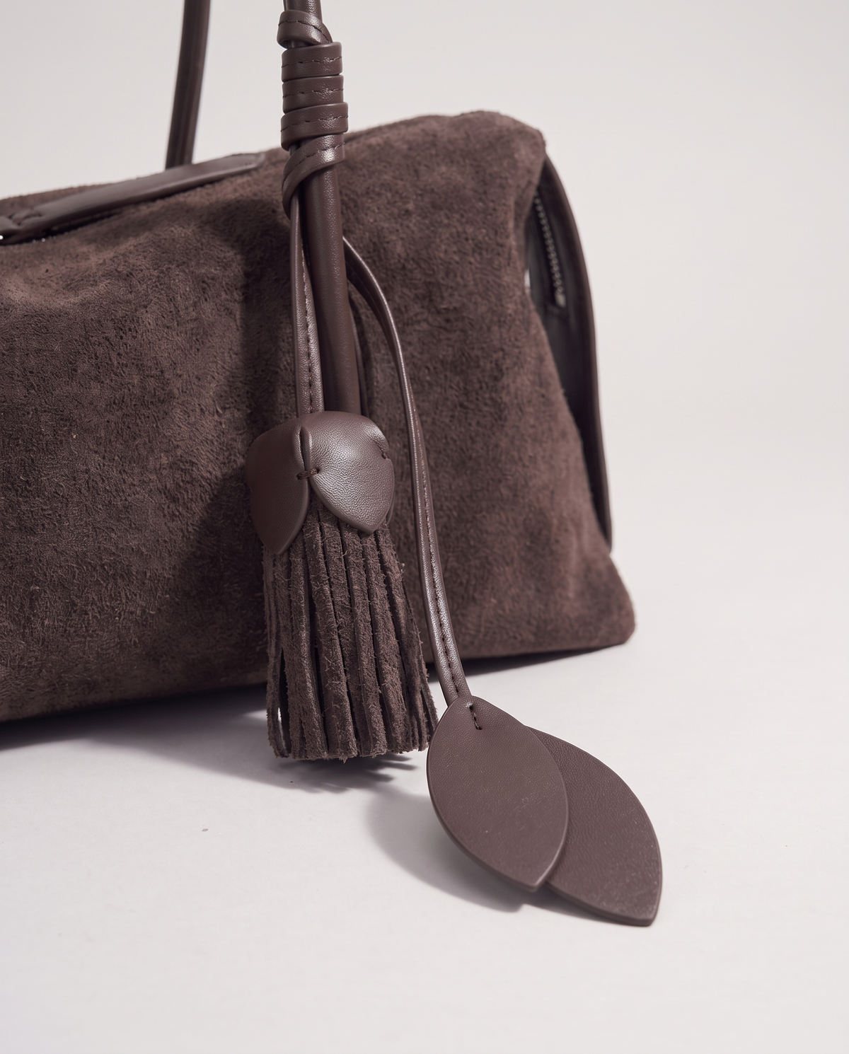 Isola suede shoulder bag in mocha, leaf and tassel charm detail