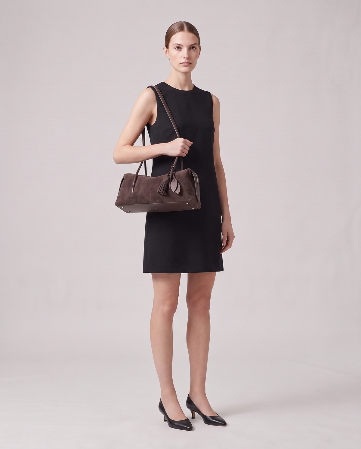 Model carrying the Isola suede shoulder bag in mocha, full length