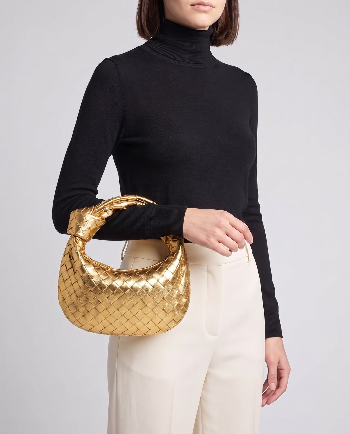 Knot Midi woven leather bag in Gold – model carrying it