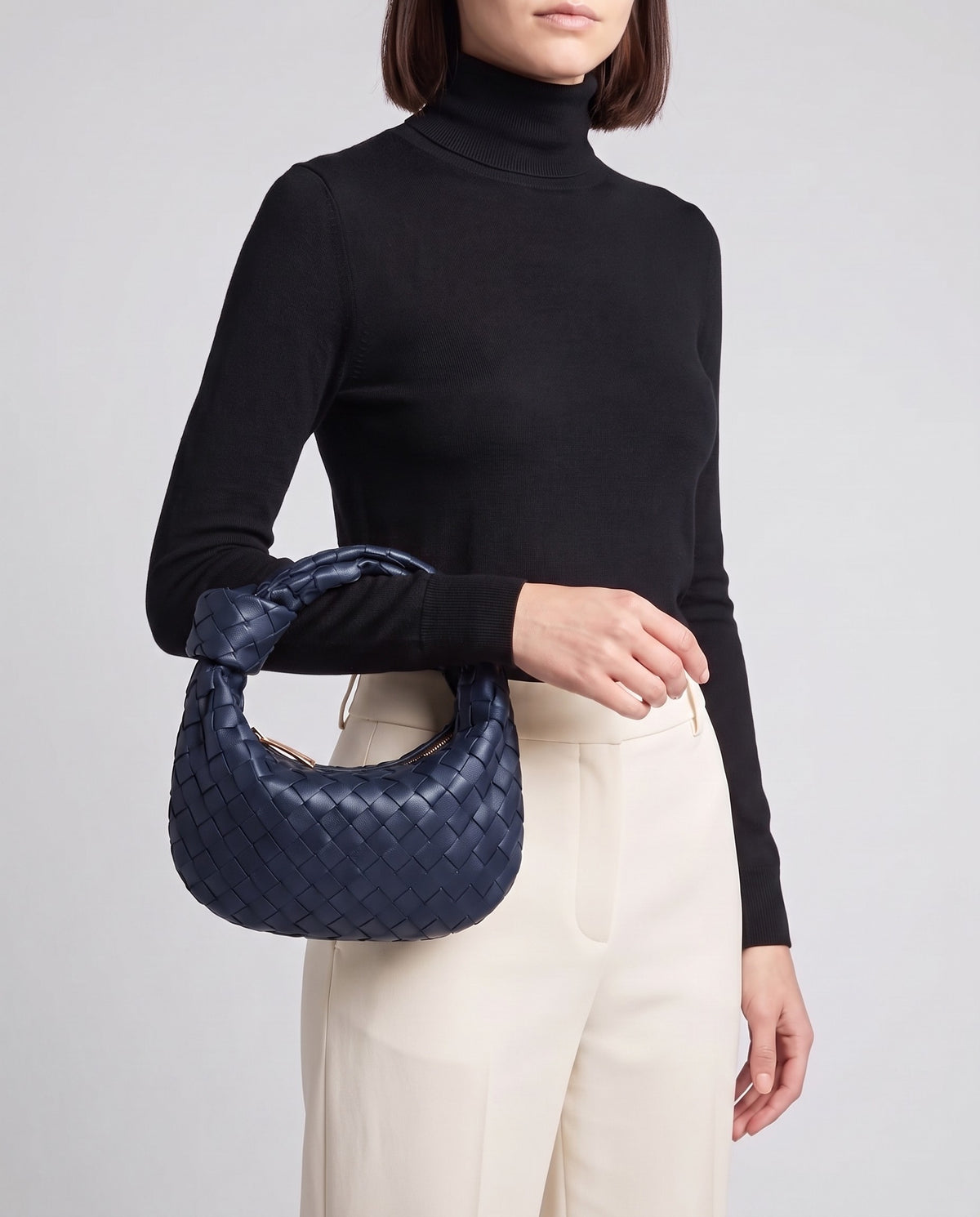 Knot Midi woven leather bag in Navy – model carrying it