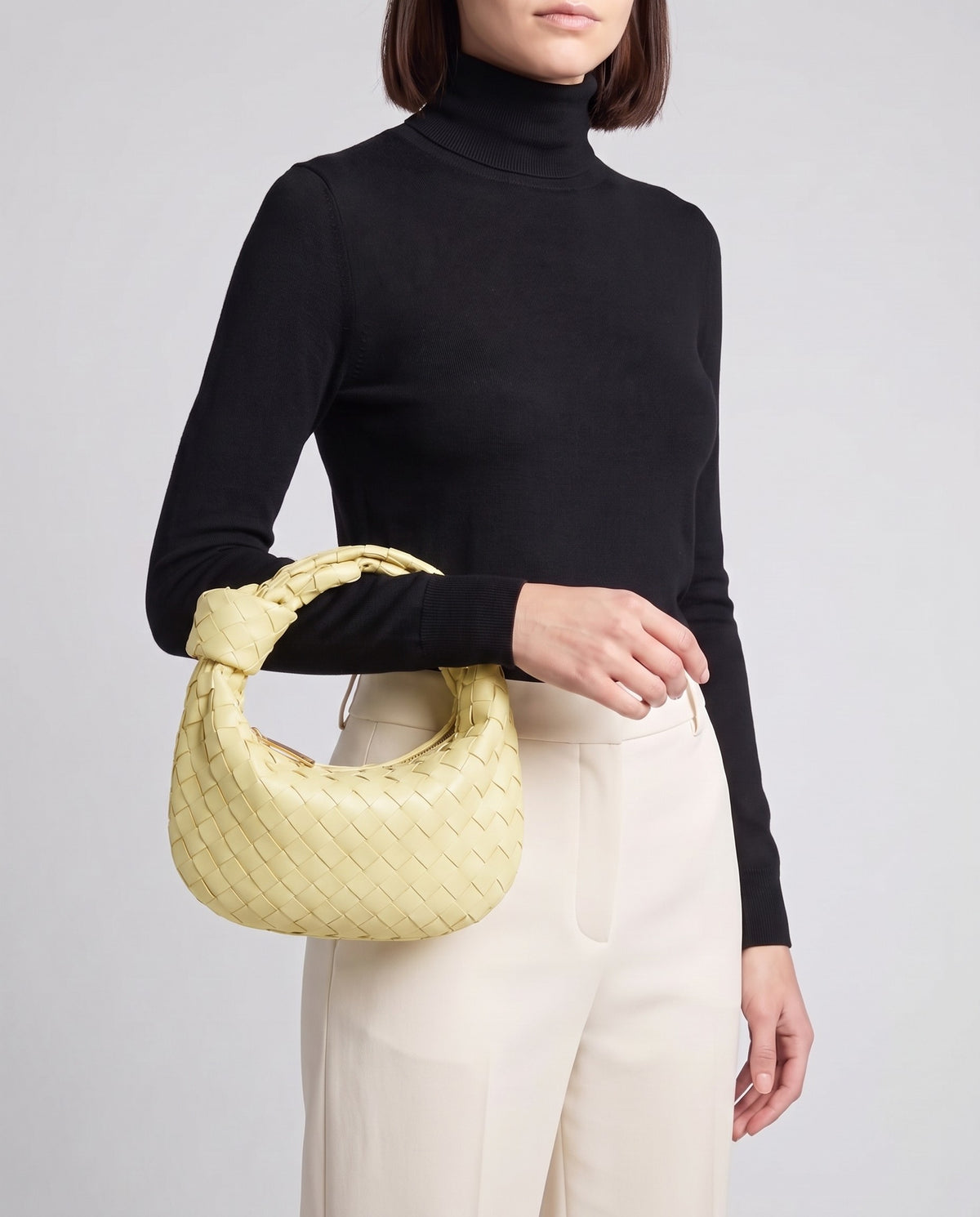 Knot Midi woven leather bag in Yellow – model carrying it