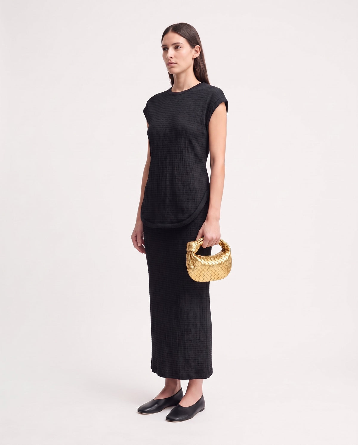 Knot Mini woven leather bag in Gold – model holding it, full length