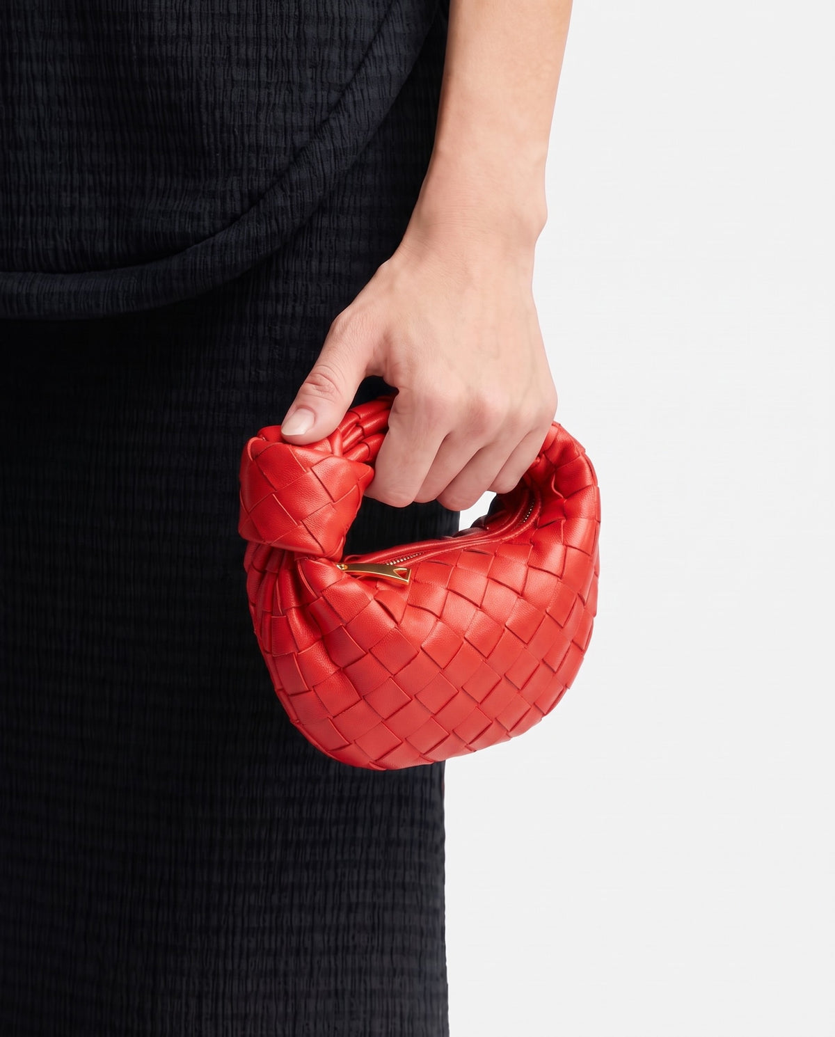 Knot Mini woven leather bag in Scarlet – held in the hand, showing true size