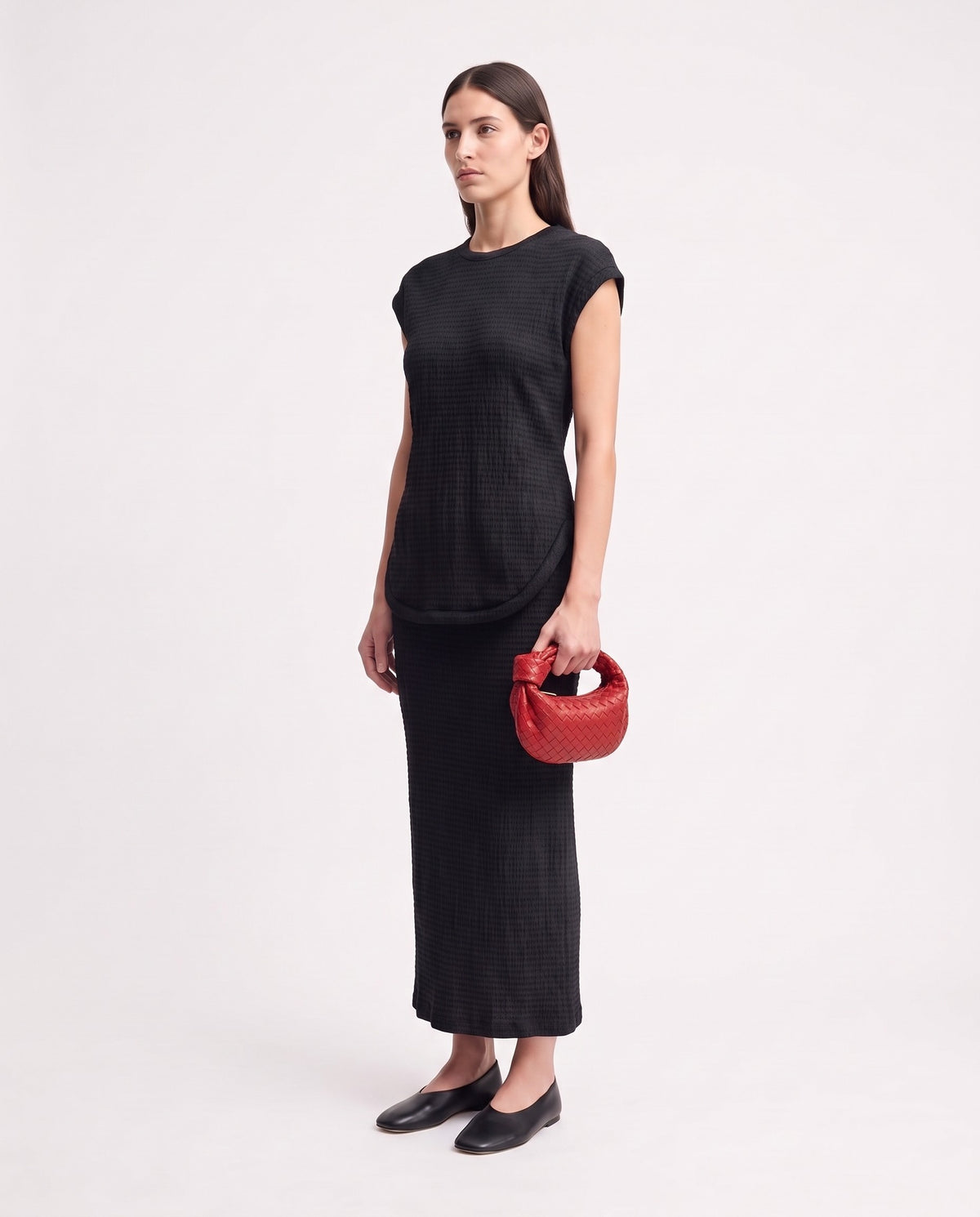 Knot Mini woven leather bag in Scarlet – model holding it, full length