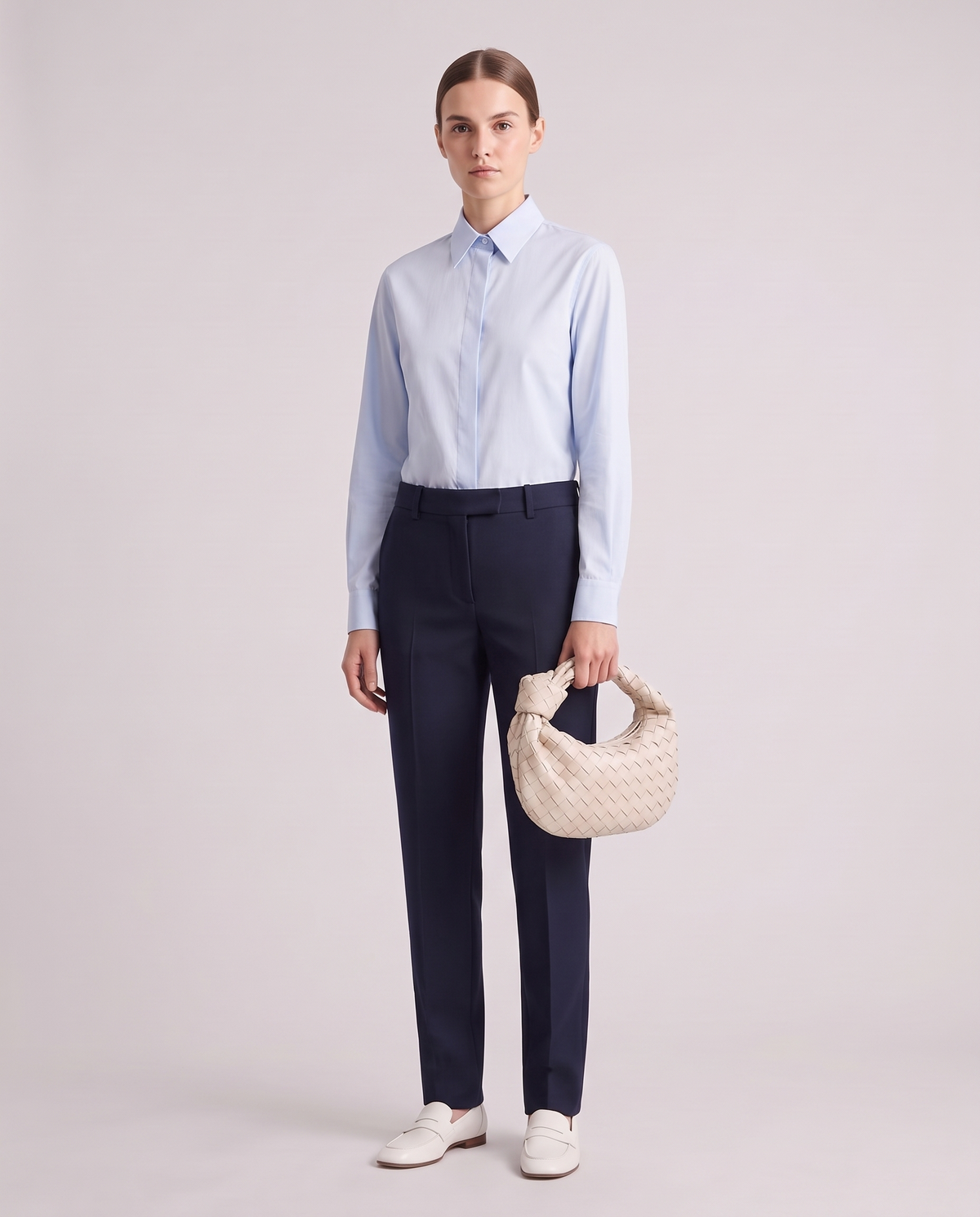 Model holding the Knot Small woven leather bag in Chalk – full length