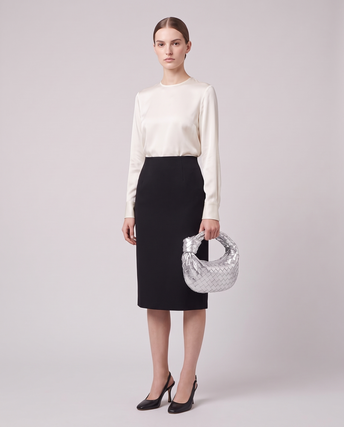 Model holding the Knot Small woven leather bag in Silver – full length