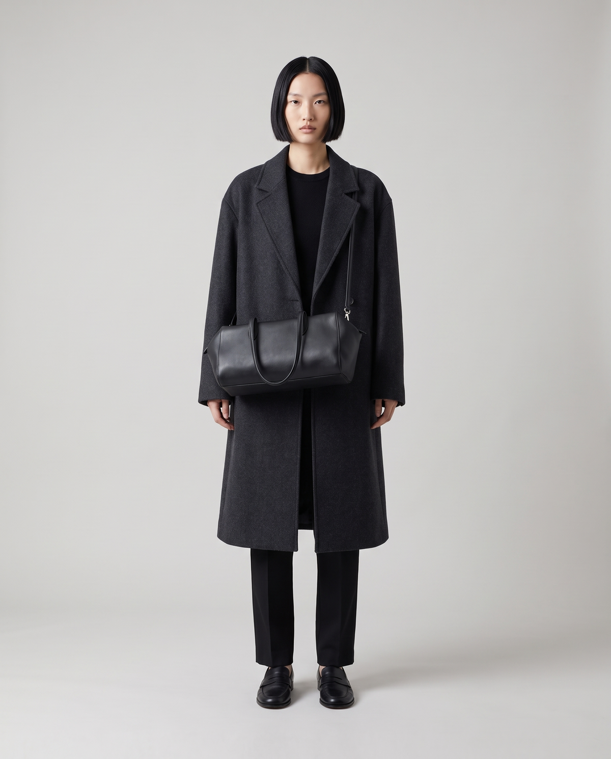 Lira leather shoulder bag in Black – model wearing it on her shoulder, full length