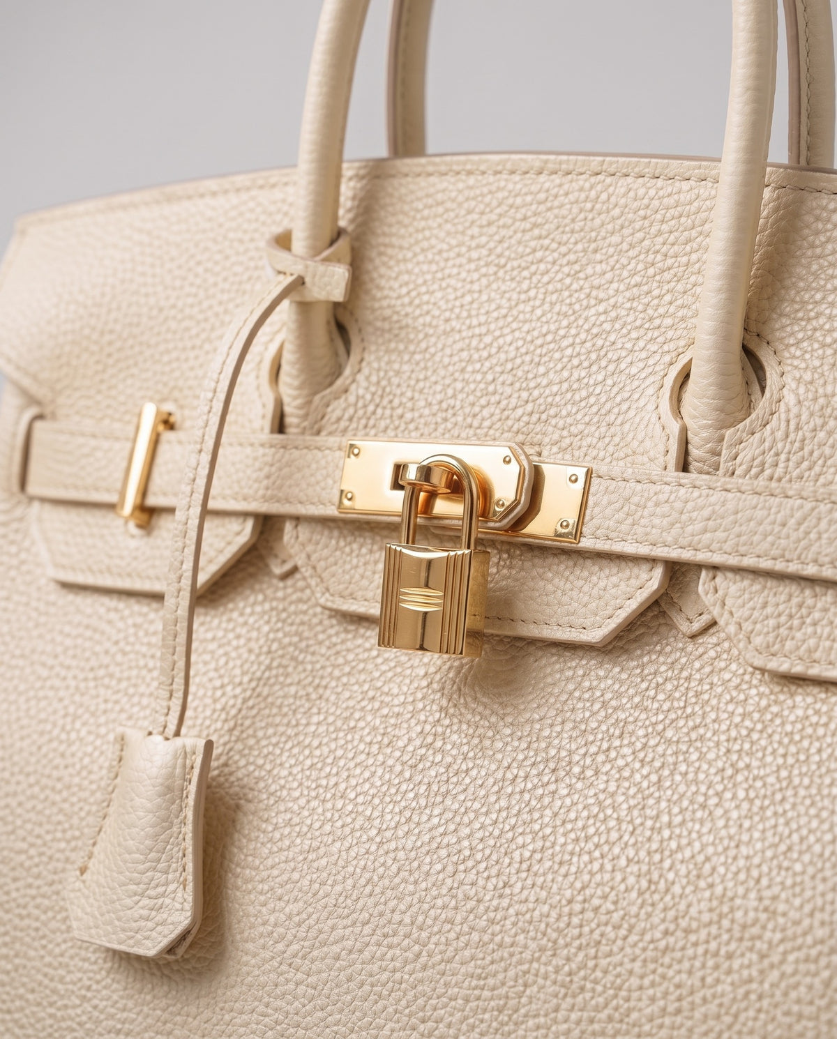 Lock Extra Large leather top-handle bag in Cream – close-up of the gold turn-lock and padlock