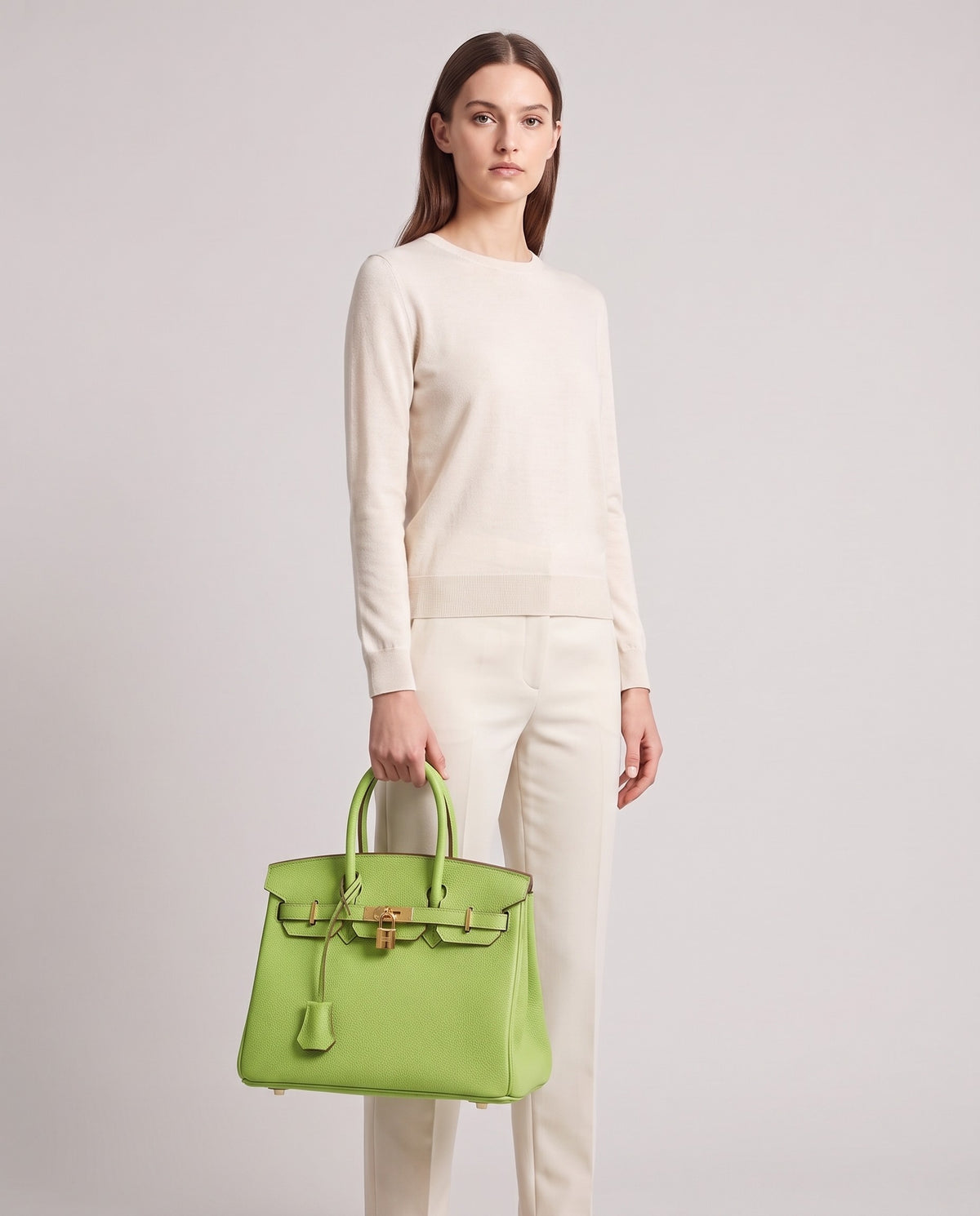 Lock Medium leather top-handle bag in Avocado – model holding it, full length