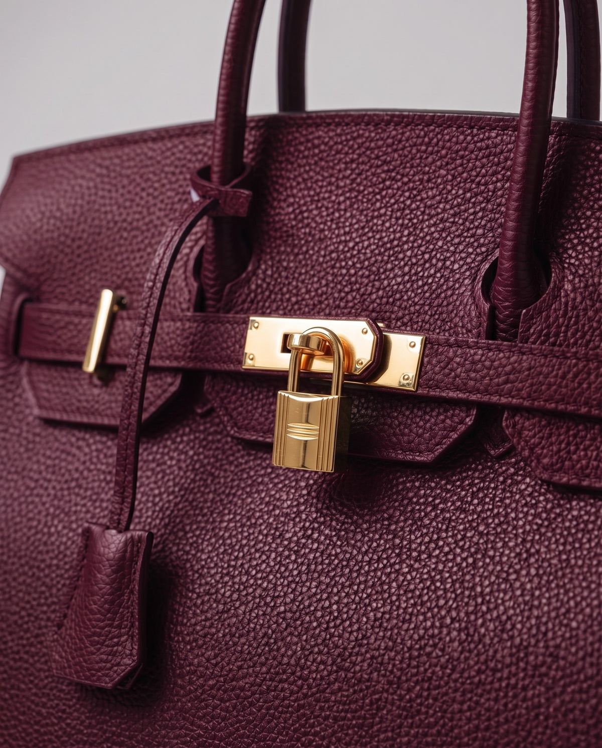 Lock Medium leather top-handle bag in Bordeaux – close-up of the gold turn-lock and padlock