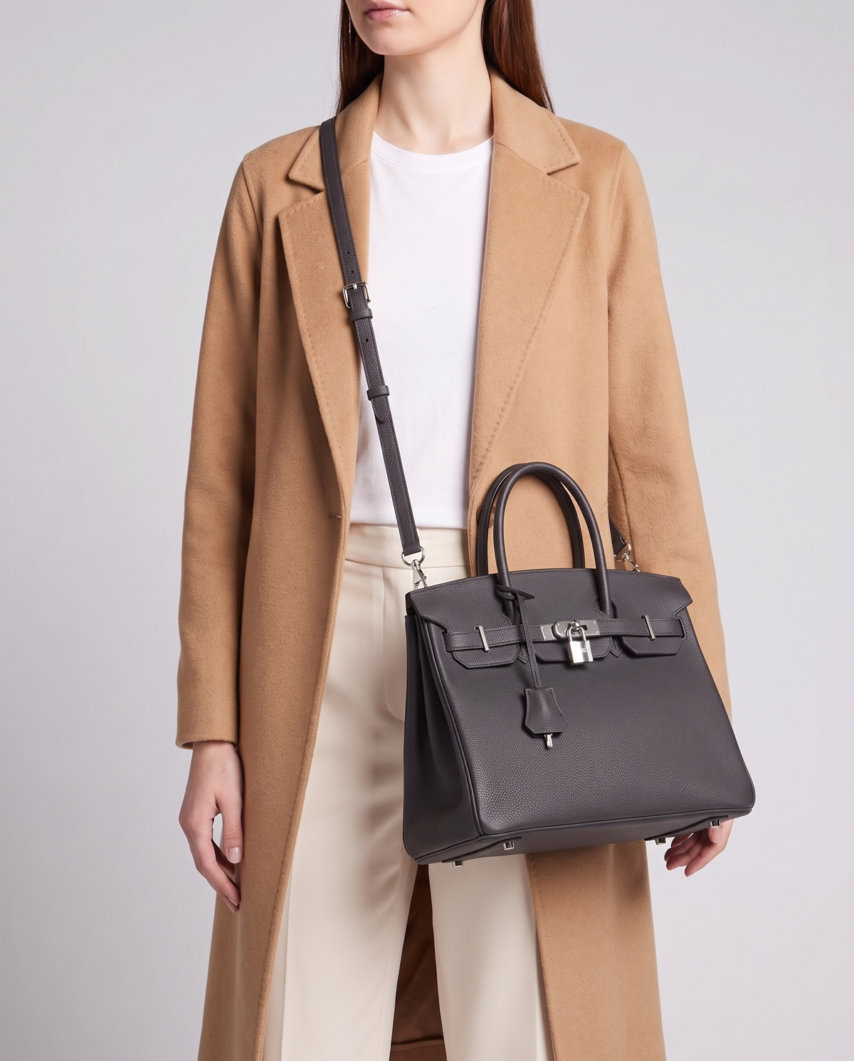 Lock Medium leather top-handle bag in Onyx – model wearing it crossbody on the detachable shoulder strap