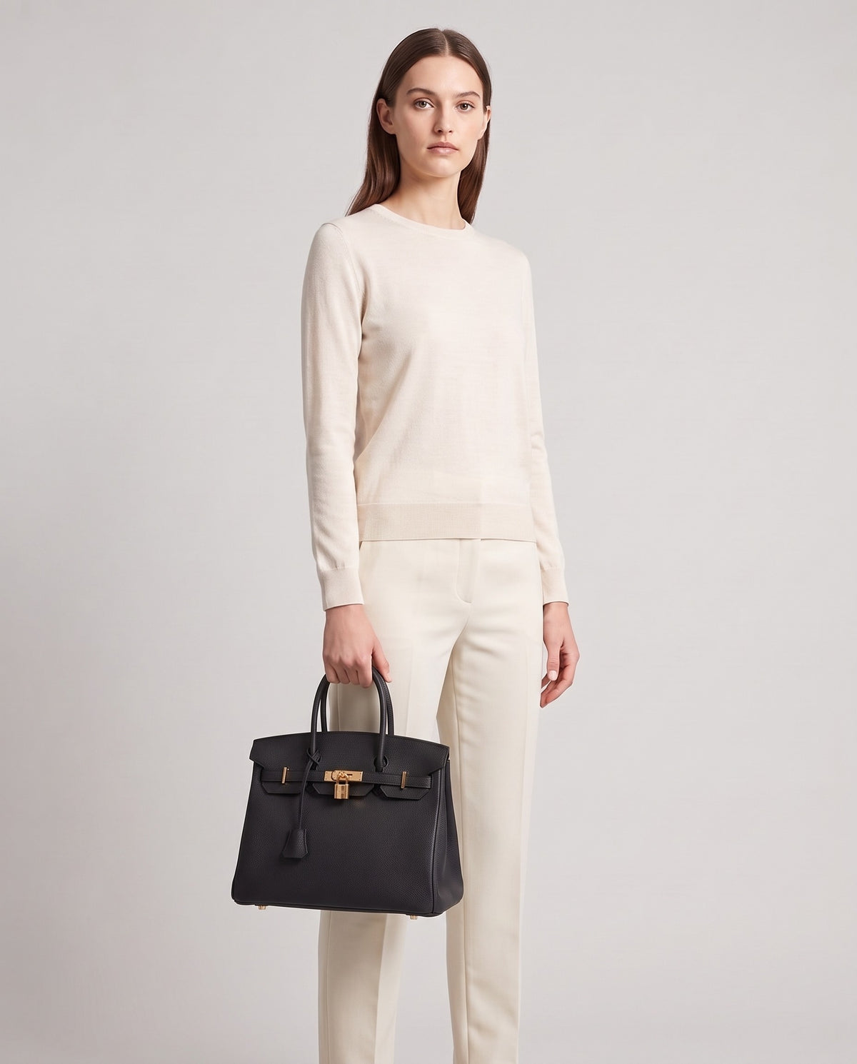 Lock Small leather top-handle bag in Black – model holding it, full length