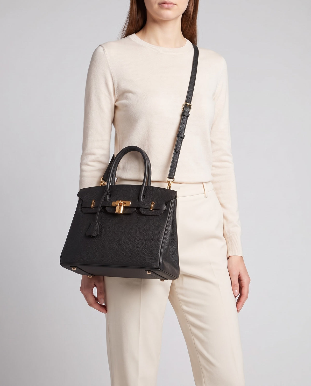 Lock Small leather top-handle bag in Black – model wearing it crossbody on the detachable shoulder strap