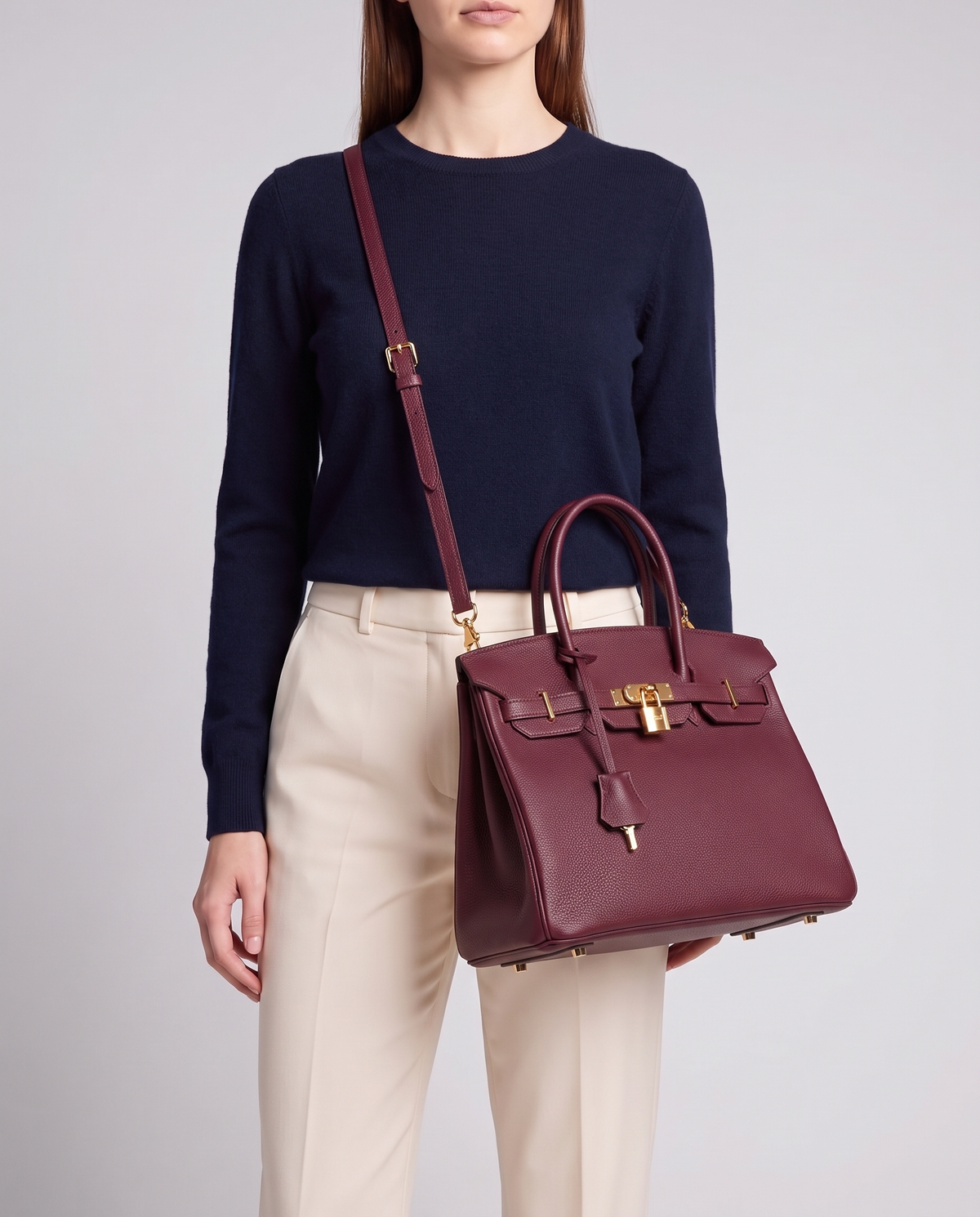 Lock Small leather top-handle bag in Bordeaux – model wearing it crossbody on the detachable shoulder strap