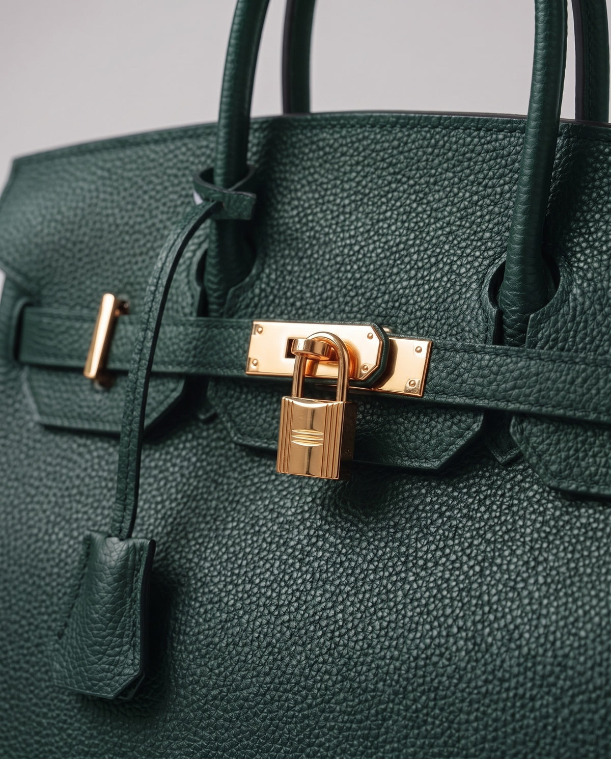 Lock Small leather top-handle bag in Emerald – close-up of the gold turn-lock and padlock