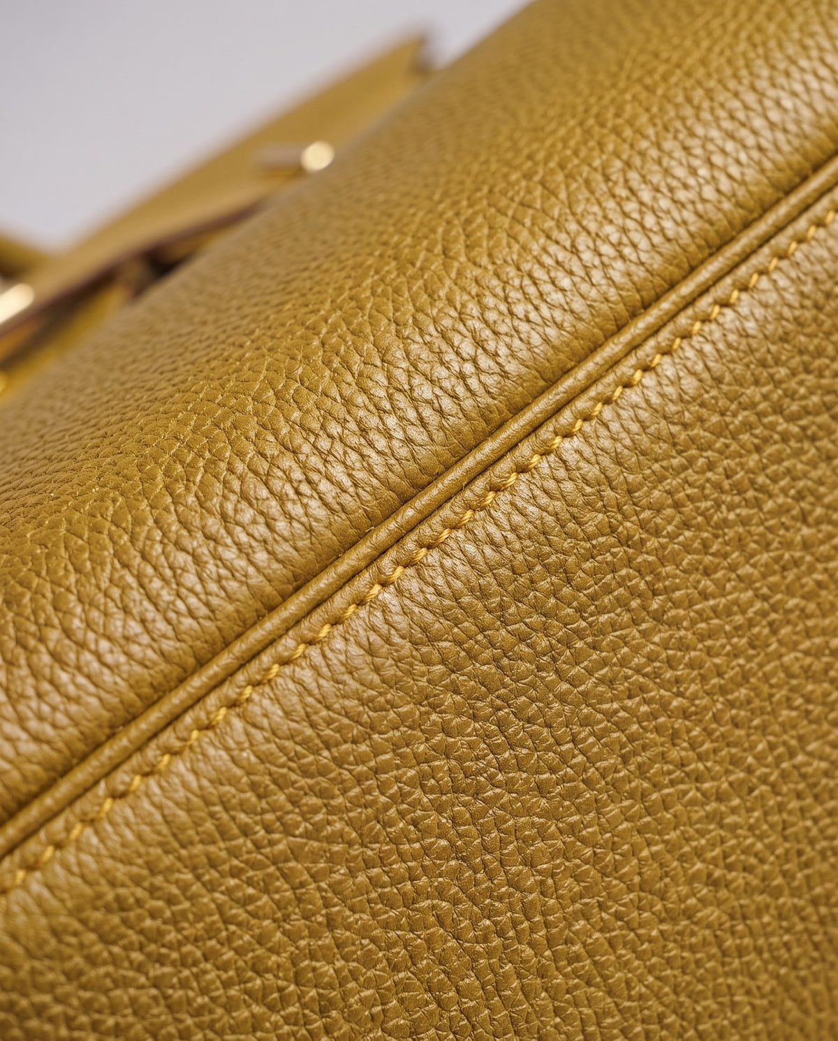 Lock Small leather top-handle bag in Mustard – close-up of the pebbled leather and stitching