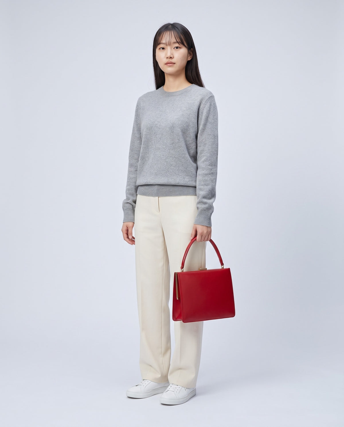 Model carrying the Marilyn top-handle bag in Red leather – full length