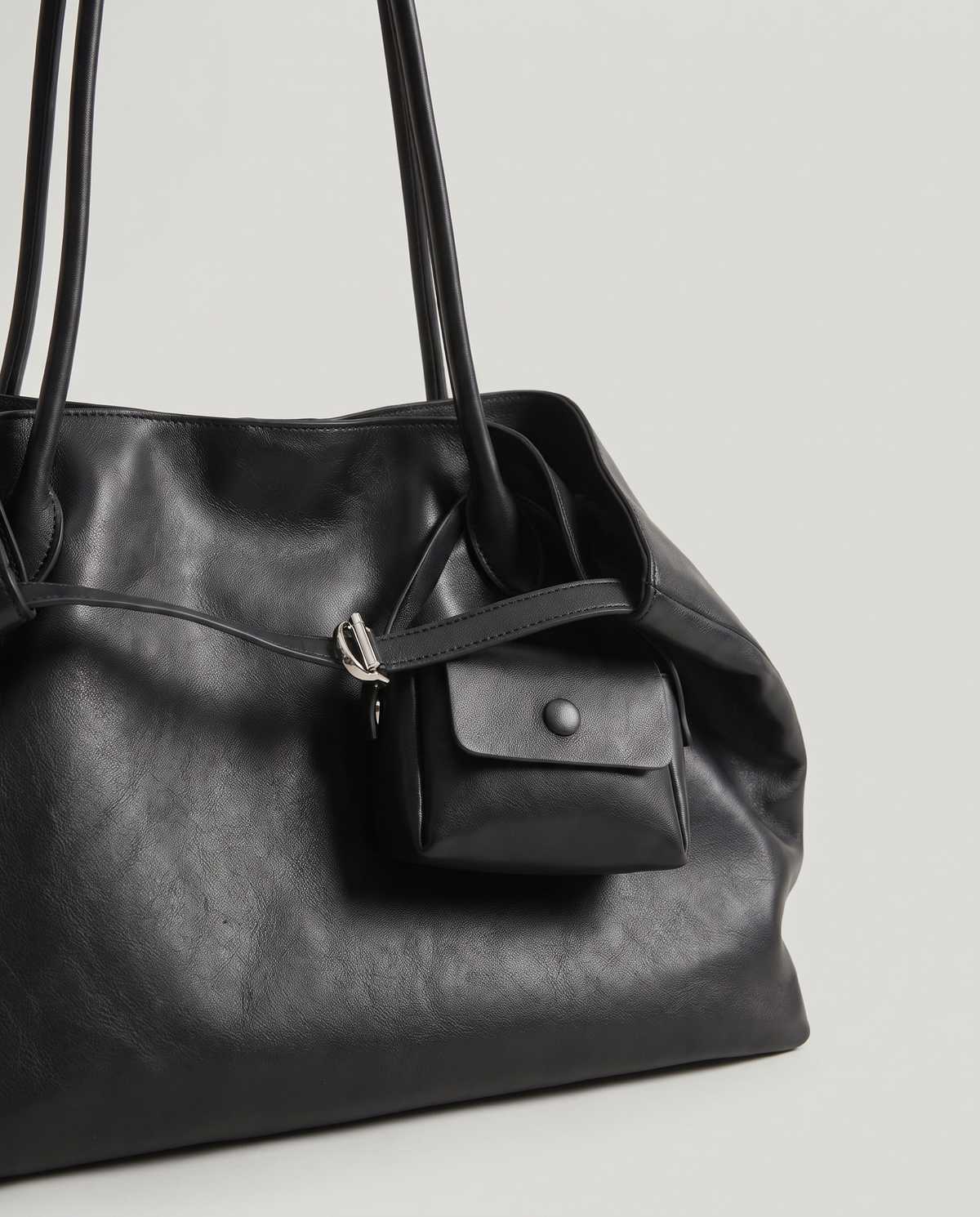 Nido leather tote in Black – close-up of the clip-on pouch and handle