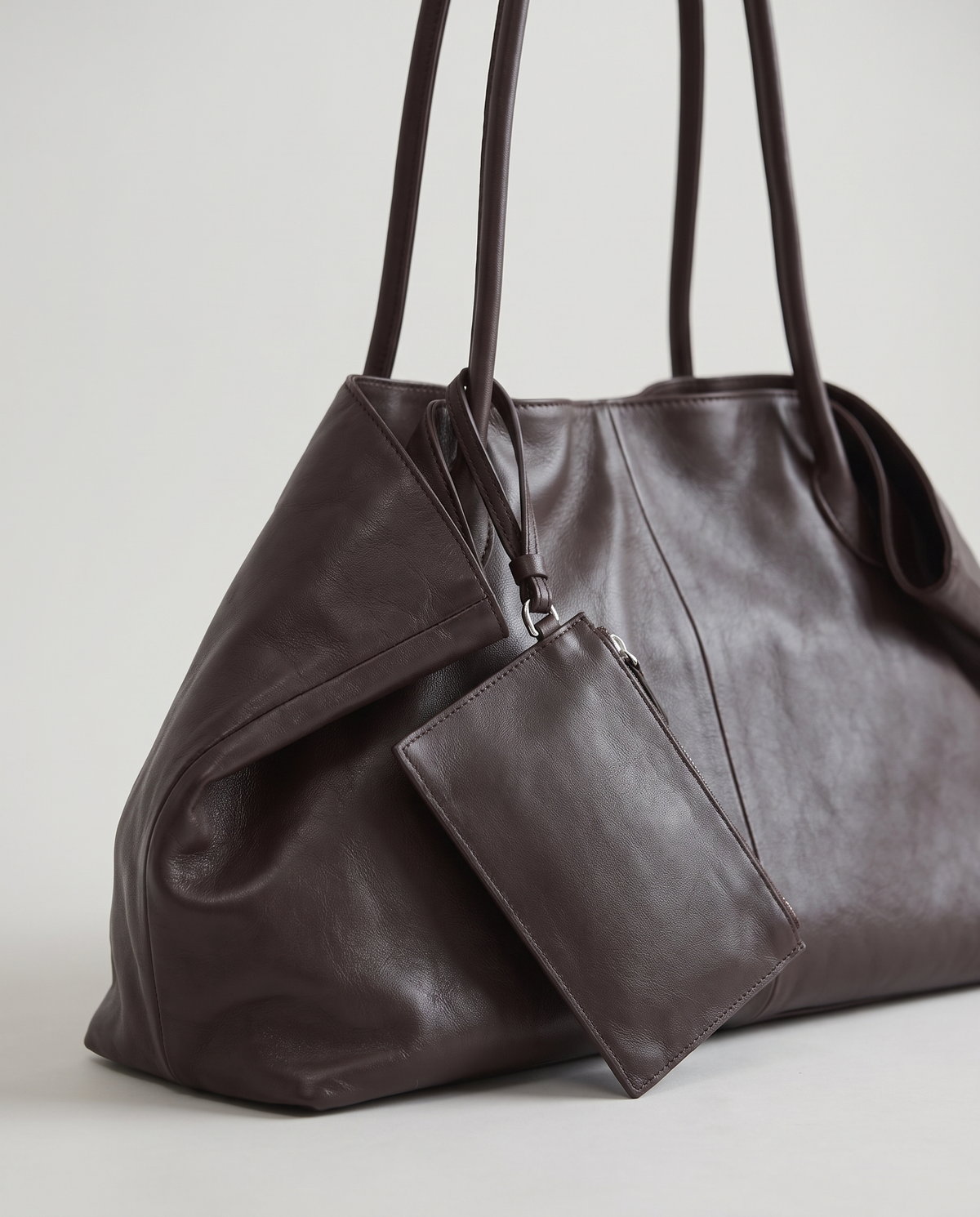 Nido leather tote in Chocolate – close-up of the clip-on pouch and handle