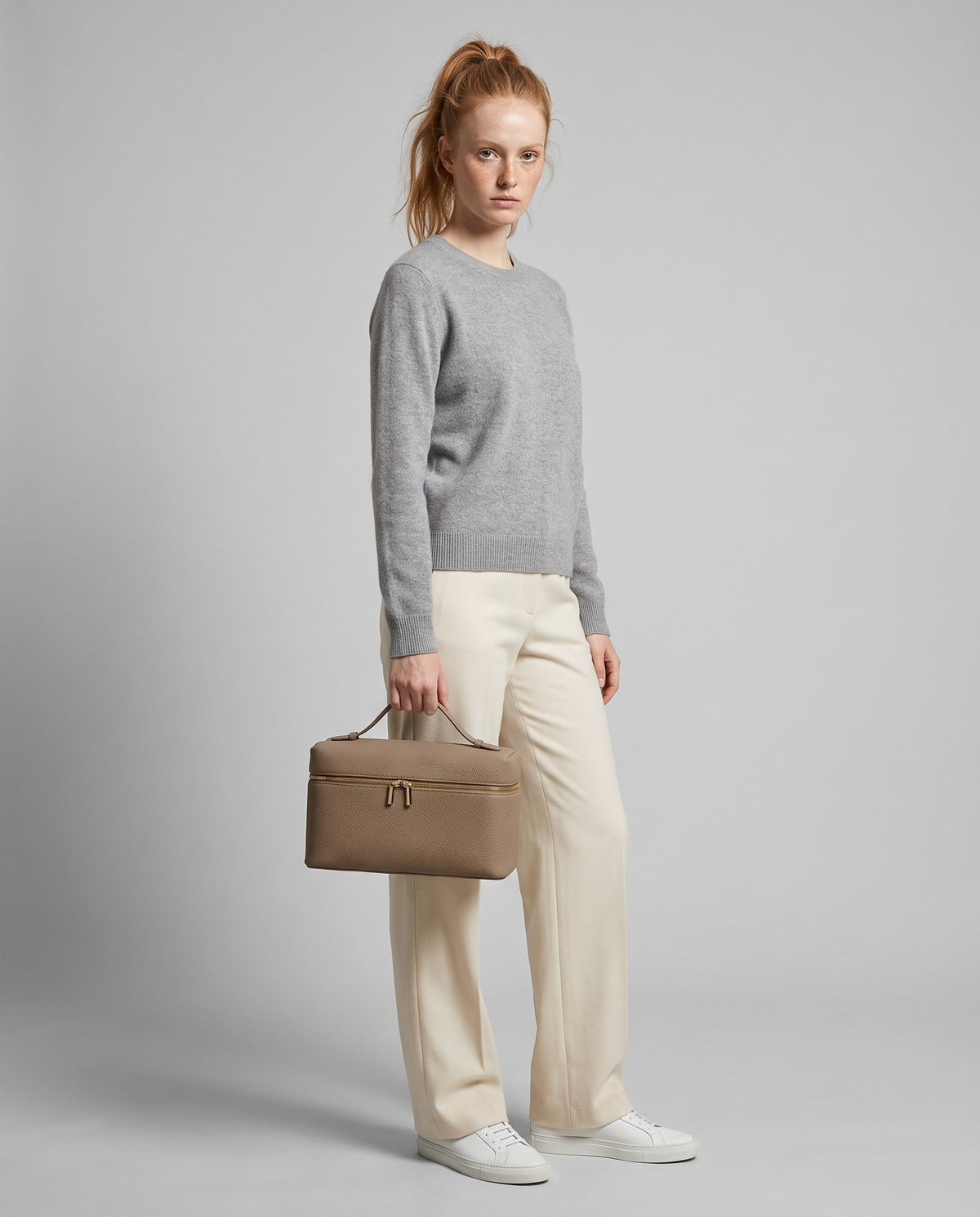 Model holding the Orvieto vanity case in Taupe – full-length view