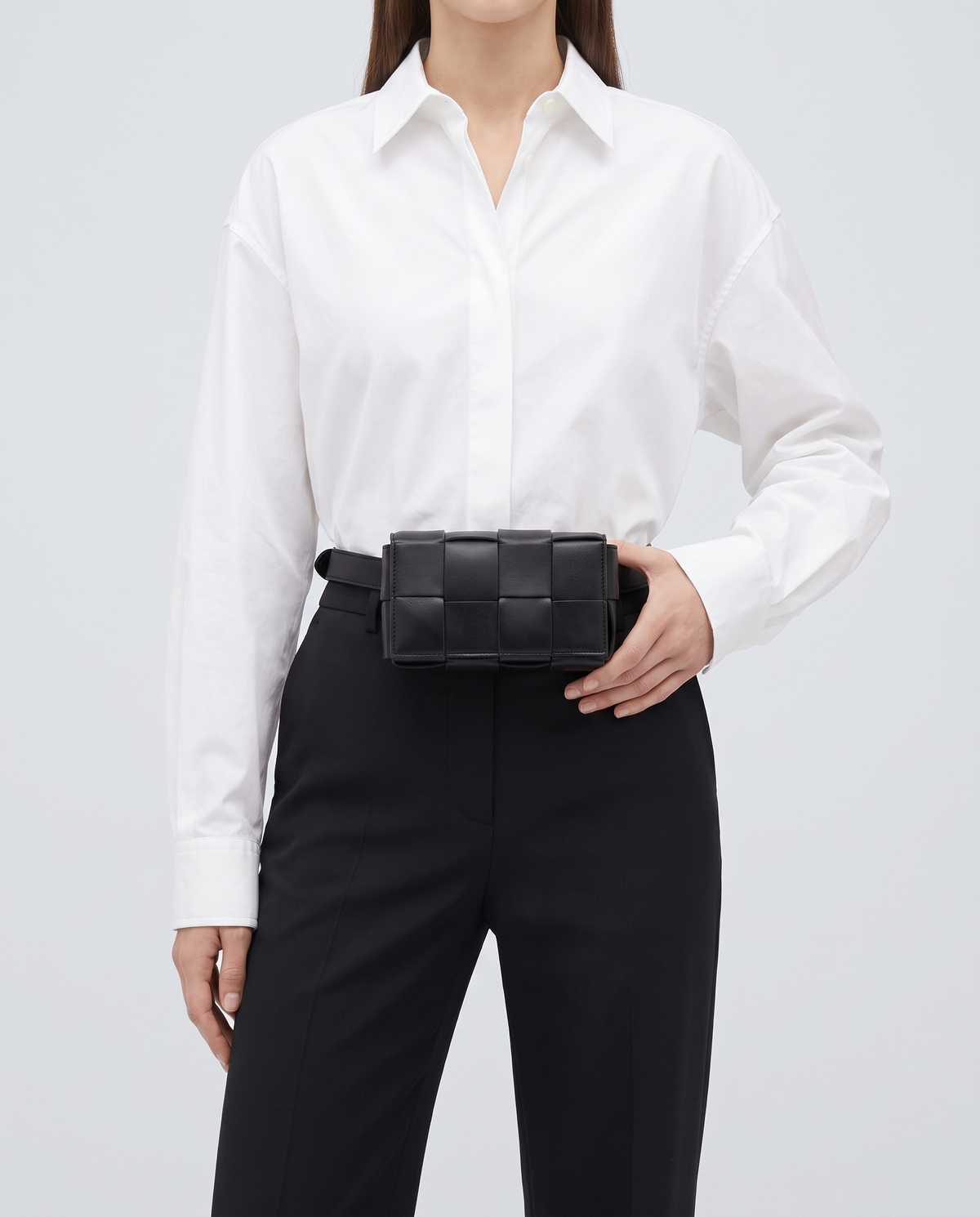 Cassette padded woven leather belt bag in Black – model wearing it at the waist