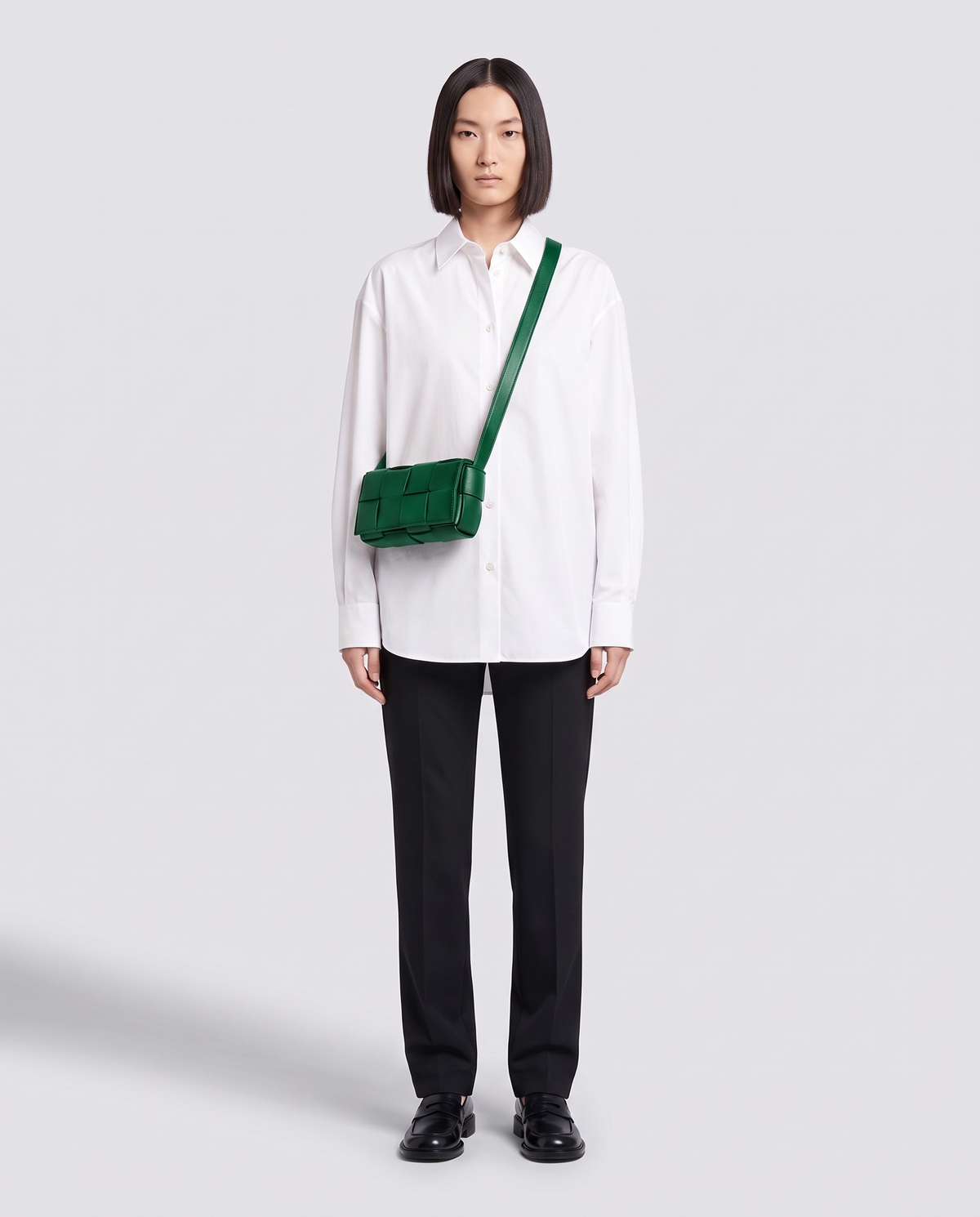 Cassette padded woven leather belt bag in Green – model wearing it crossbody, full length