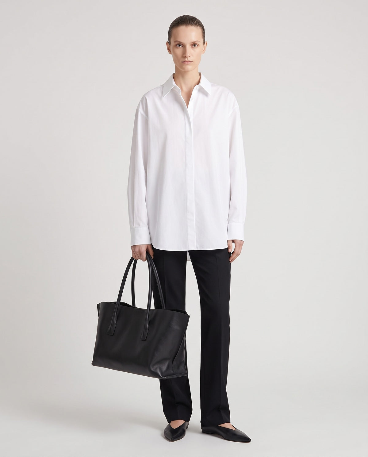 Piano leather tote in Black – model holding it, full length