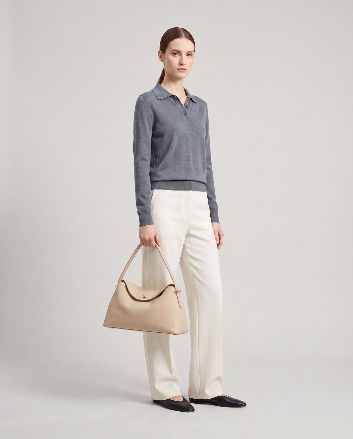 Model holding the Porto top-handle bag in beige, full length
