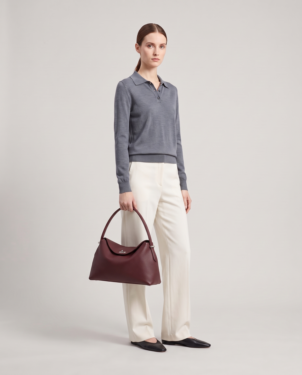 Model with the Porto pebbled leather top-handle bag in burgundy, full length