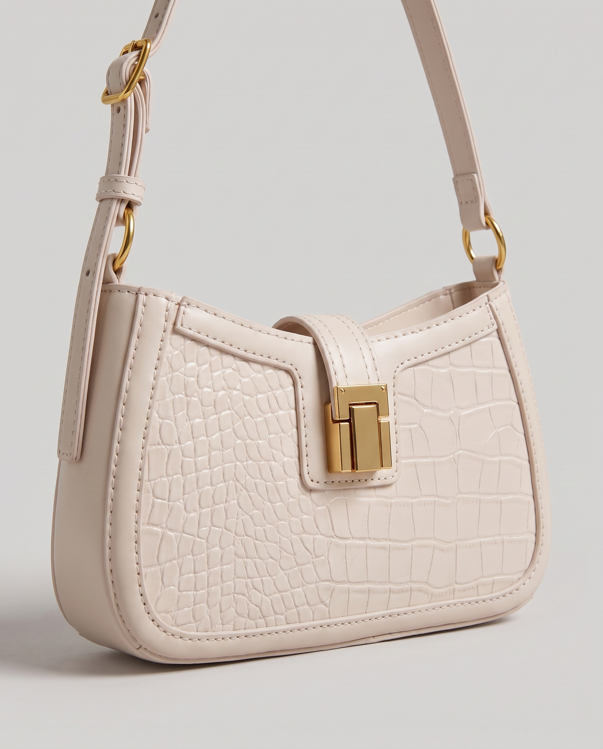 Sable croc-embossed shoulder bag in Chalk – close-up of the gold push-lock clasp