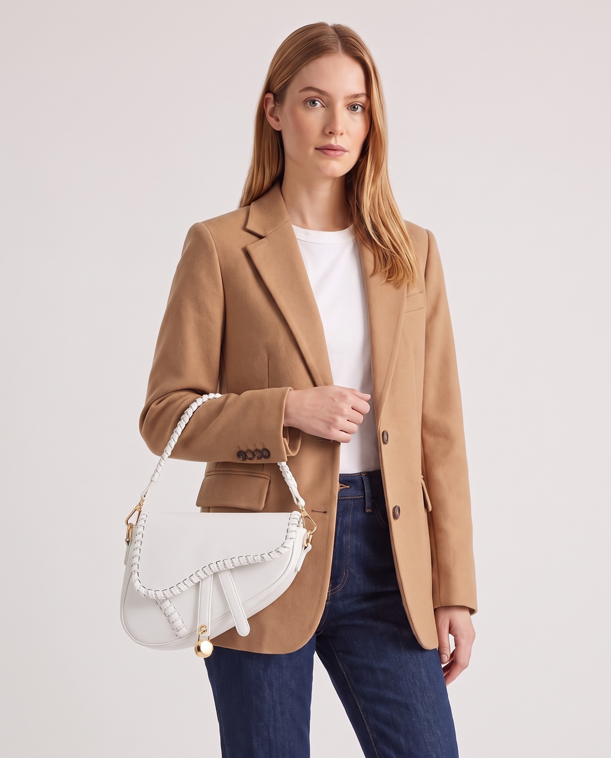 Saddle vegan leather shoulder bag in White – model wearing it on the shoulder, waist-up