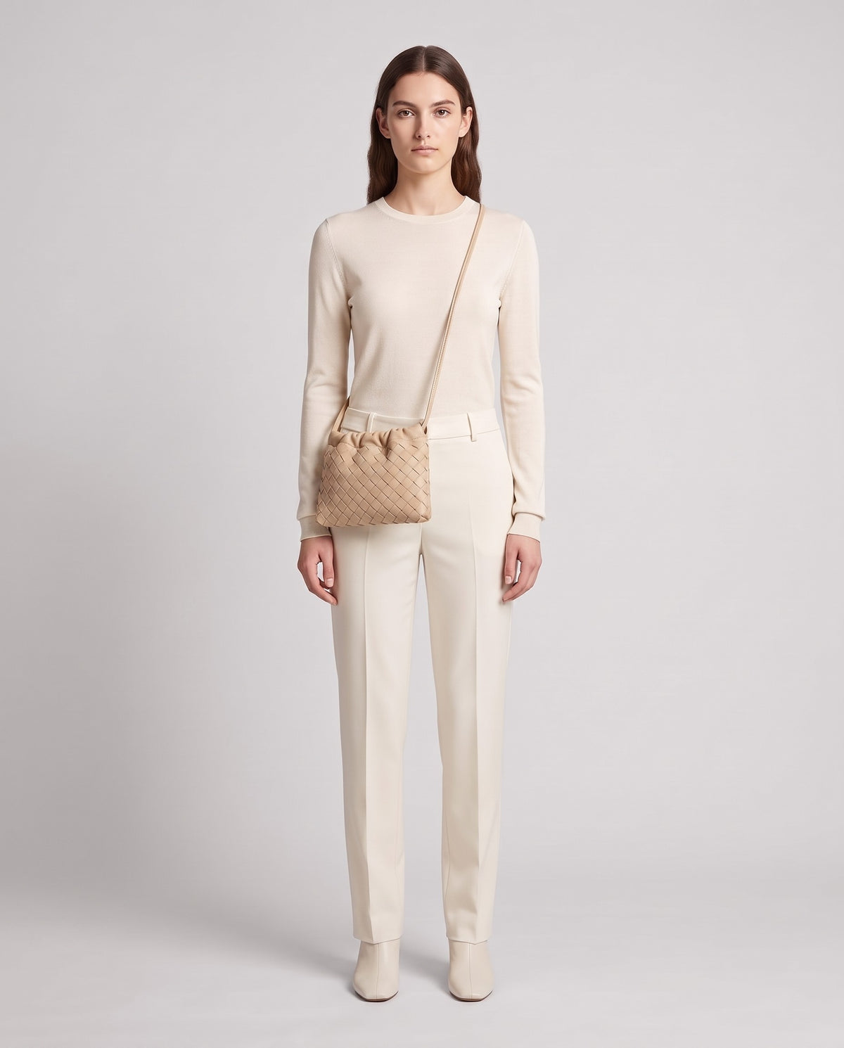 Model wearing the Serata woven leather clutch in Beige – full length
